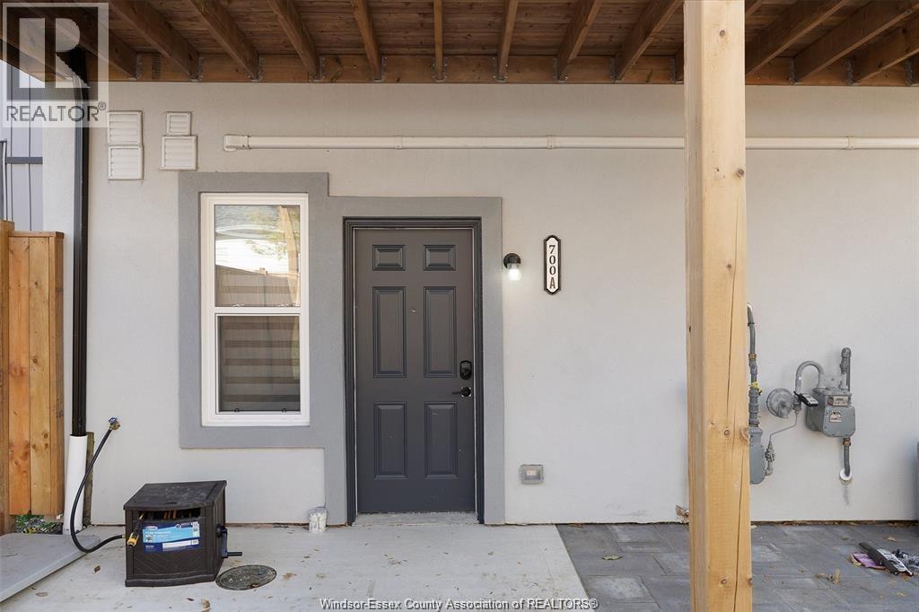 A black door is on the right side of a white wall.