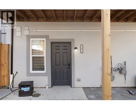 A black door is on the right side of a white wall.