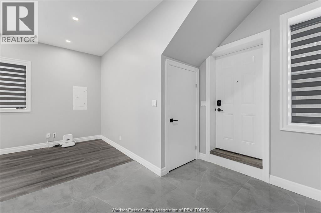 A room with a door and a window with blinds.