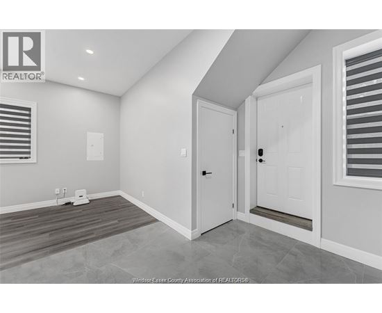 A room with a door and a window with blinds.