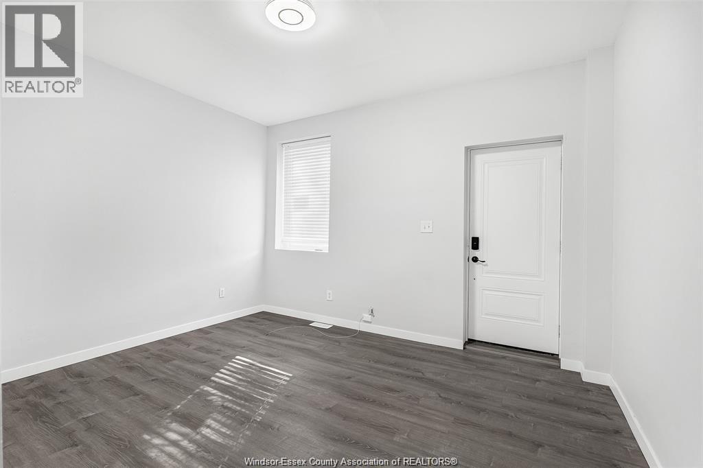 A room with a white door and a window with blinds.