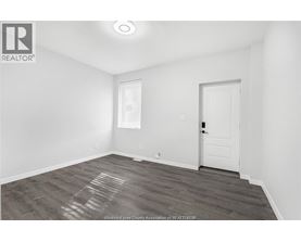 A room with a white door and a window with blinds.