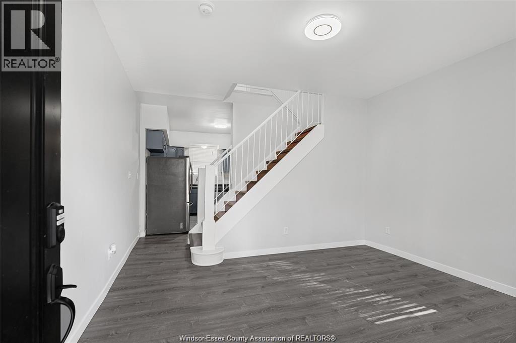 A spacious room with a staircase leading to the upper floor.
