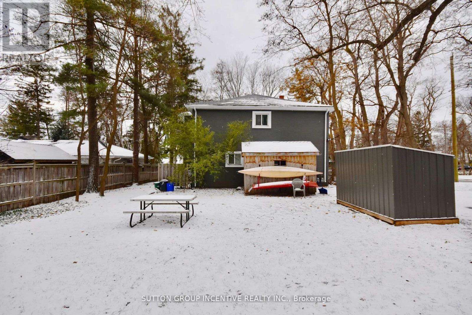 A snow-covered backyard with a picnic table and a shed.
