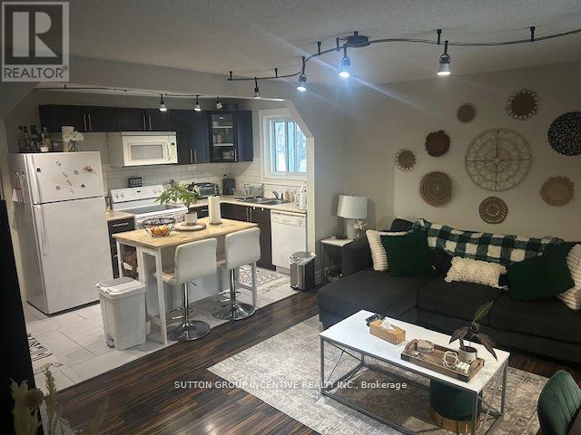 A well-lit kitchen and living room with a dining table and chairs.