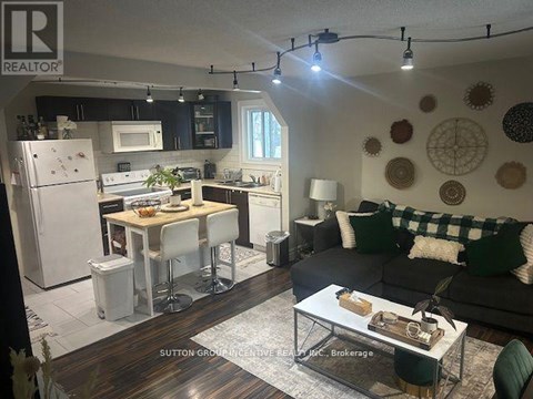 A well-lit kitchen and living room with a dining table and chairs.