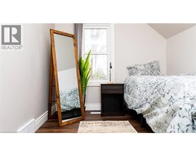 A bedroom with a bed, a dresser, and a mirror.