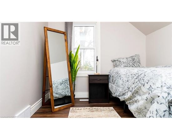 A bedroom with a bed, a dresser, and a mirror.