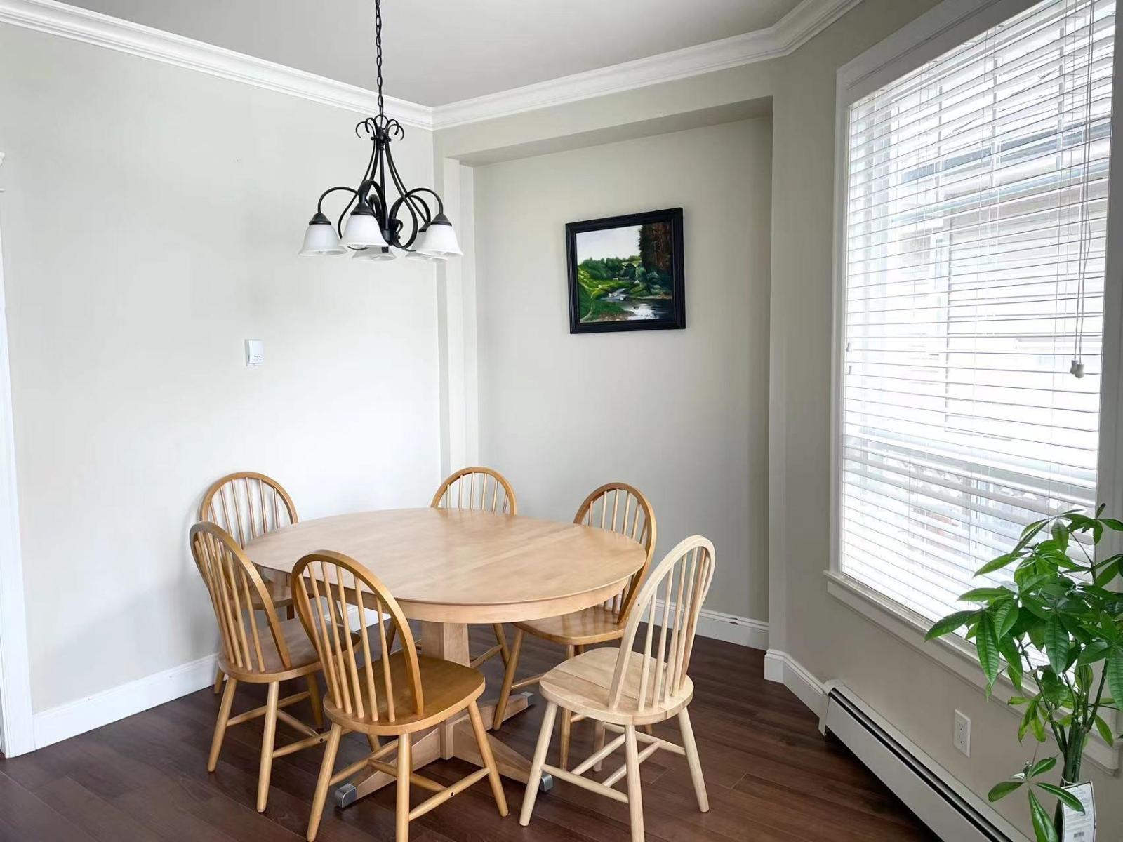 A dining room with a wooden table and chairs.