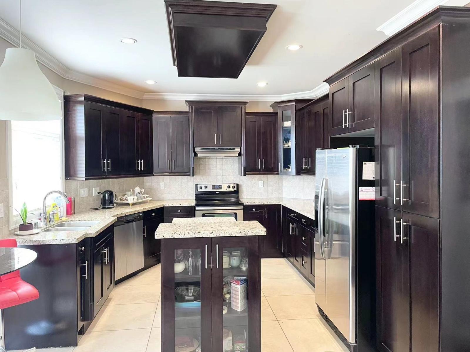 A kitchen with dark wood cabinets and stainless steel appliances.