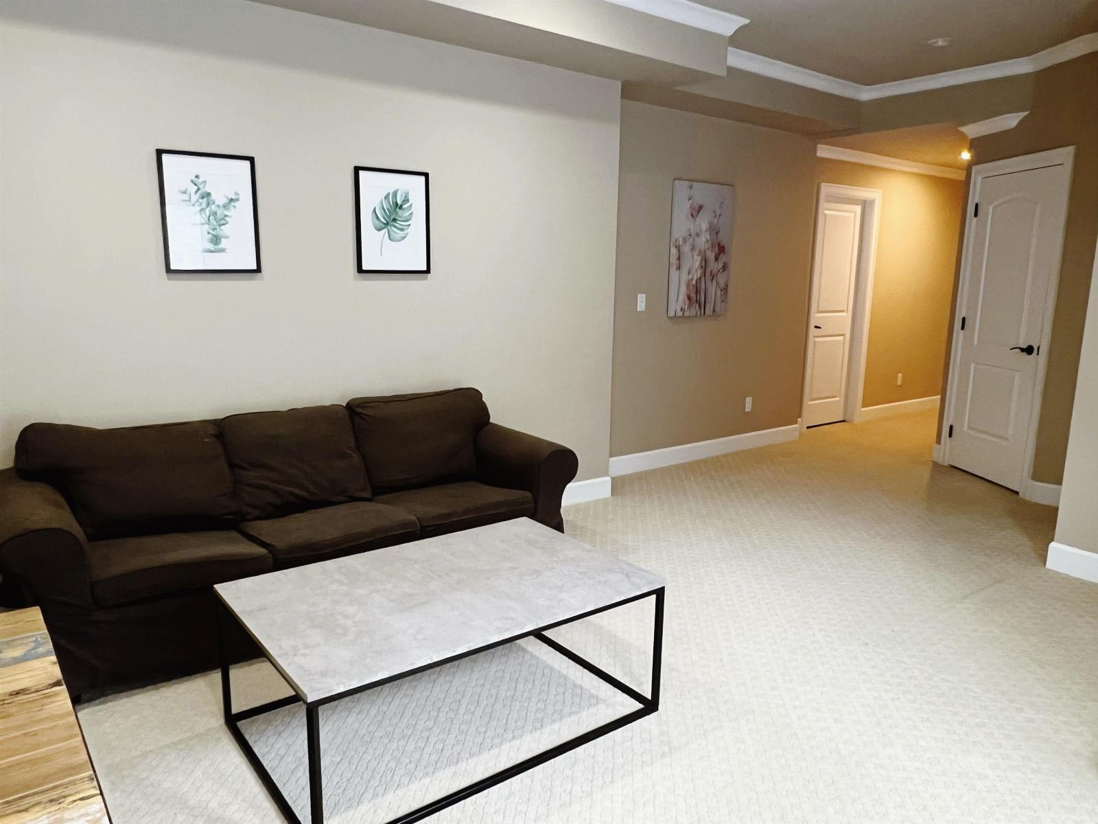 A living room with a brown couch and a coffee table.