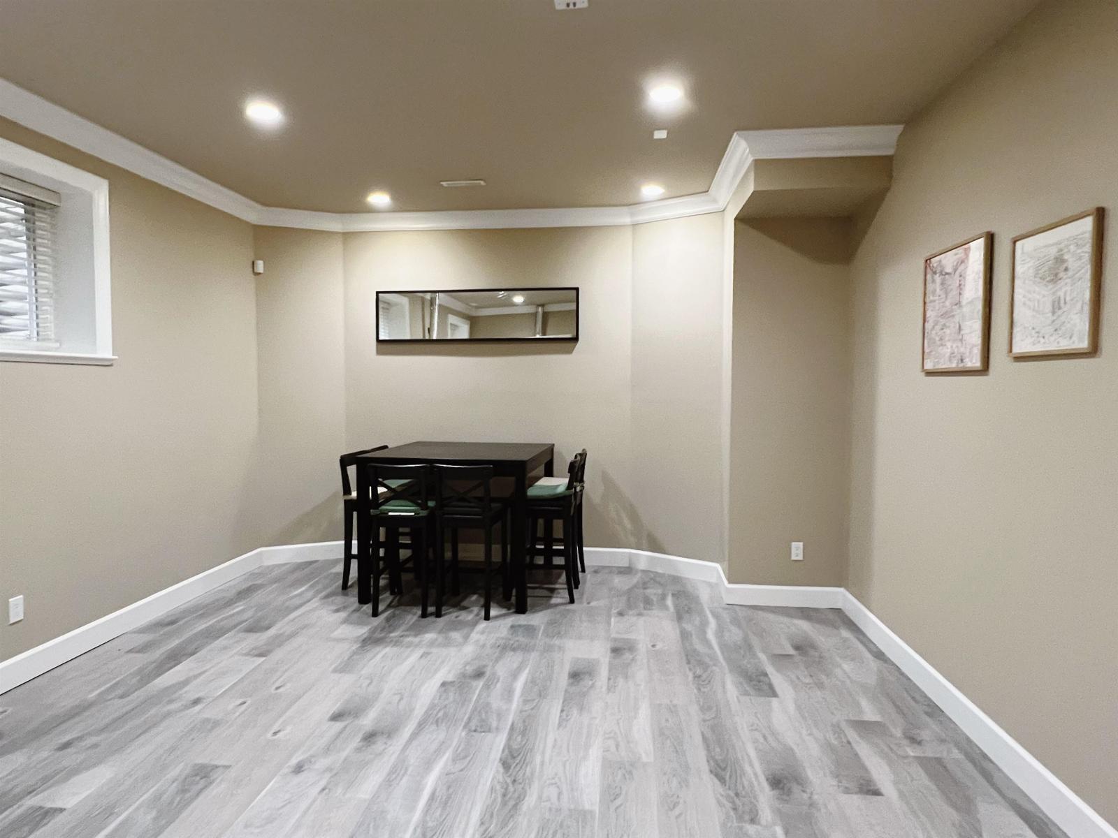 A dining room with a wooden table and chairs.