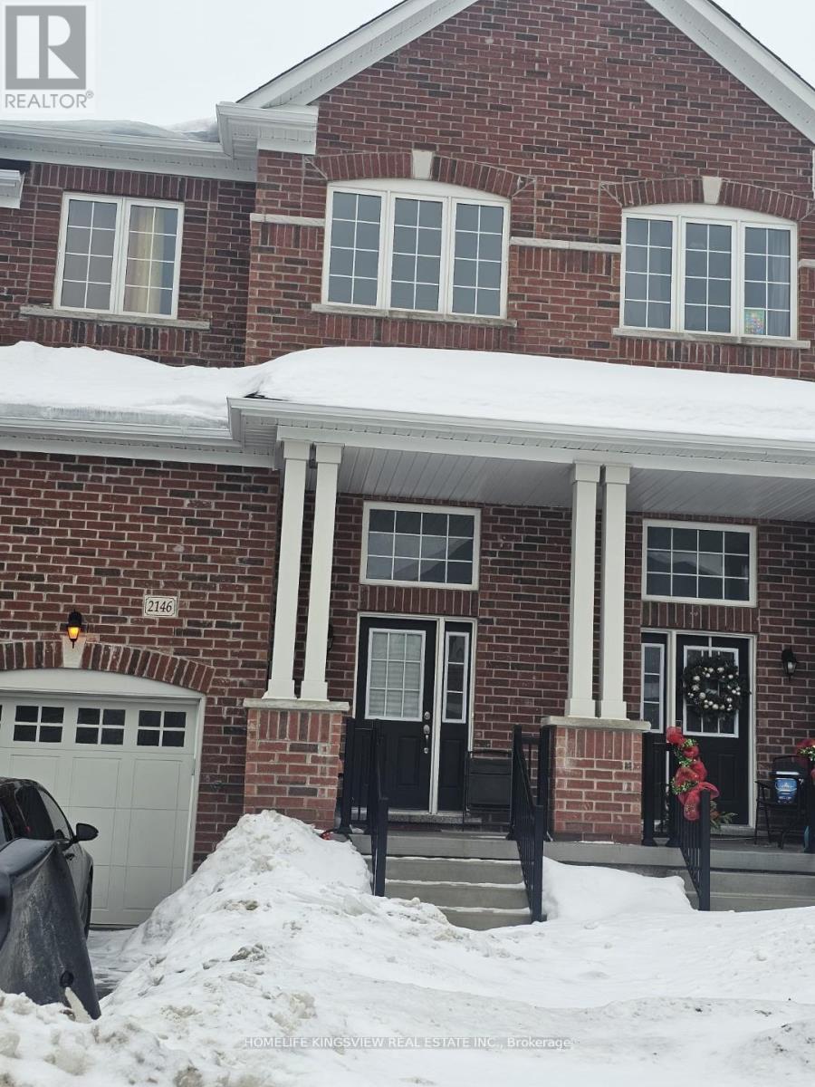 A red brick house with a black door and a garage.