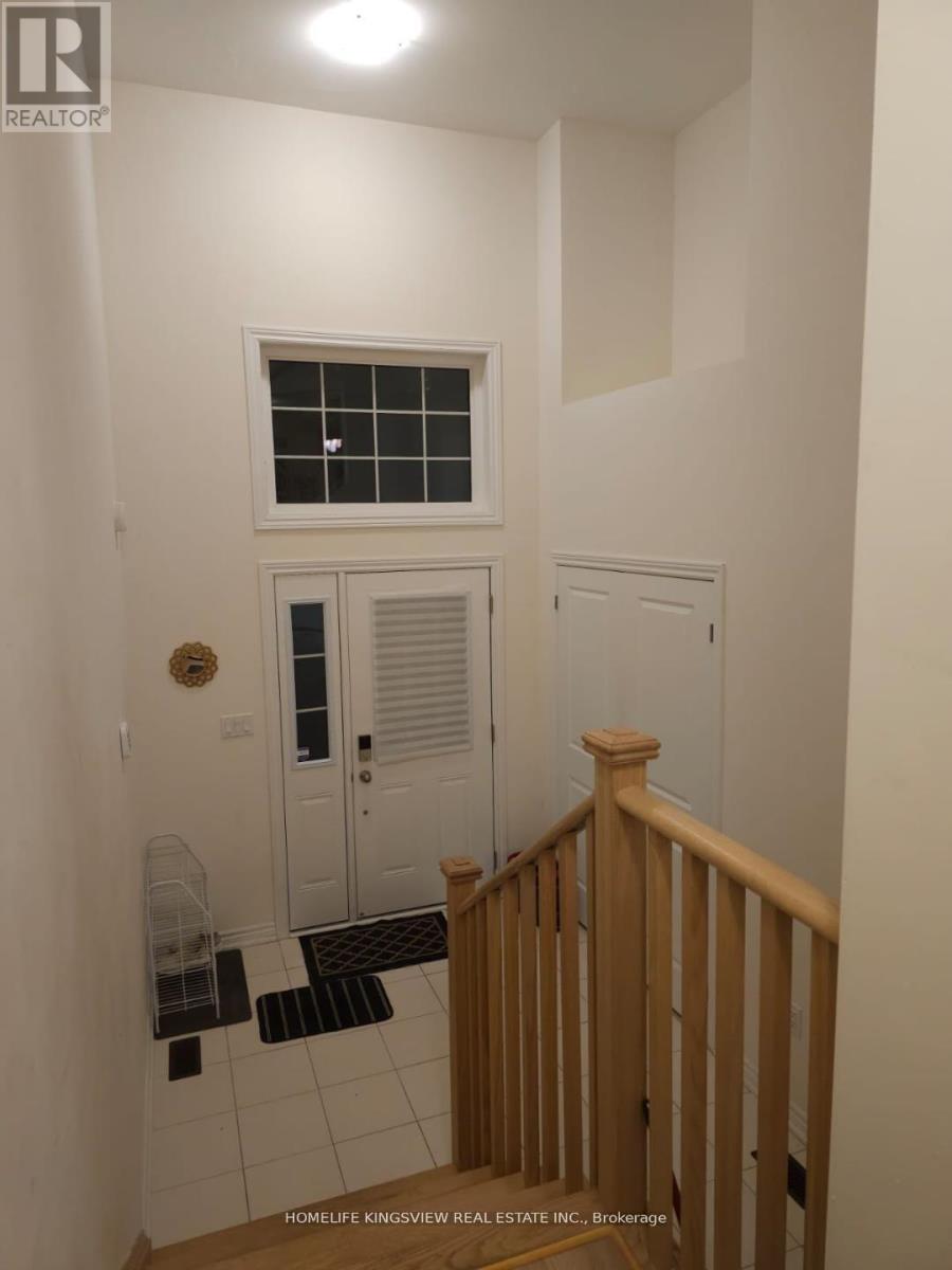 A white hallway with a wooden railing and a white door.
