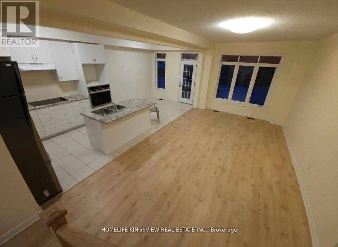 A kitchen with white cabinets and a wooden floor.