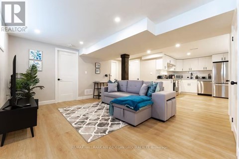 A living room with a couch and a rug in the middle.