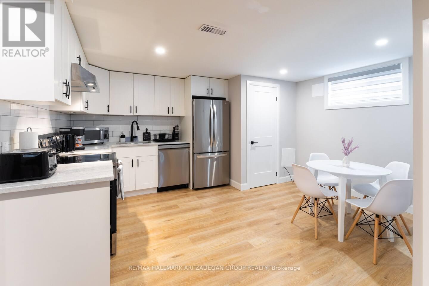 A kitchen with white cabinets and a wooden floor.