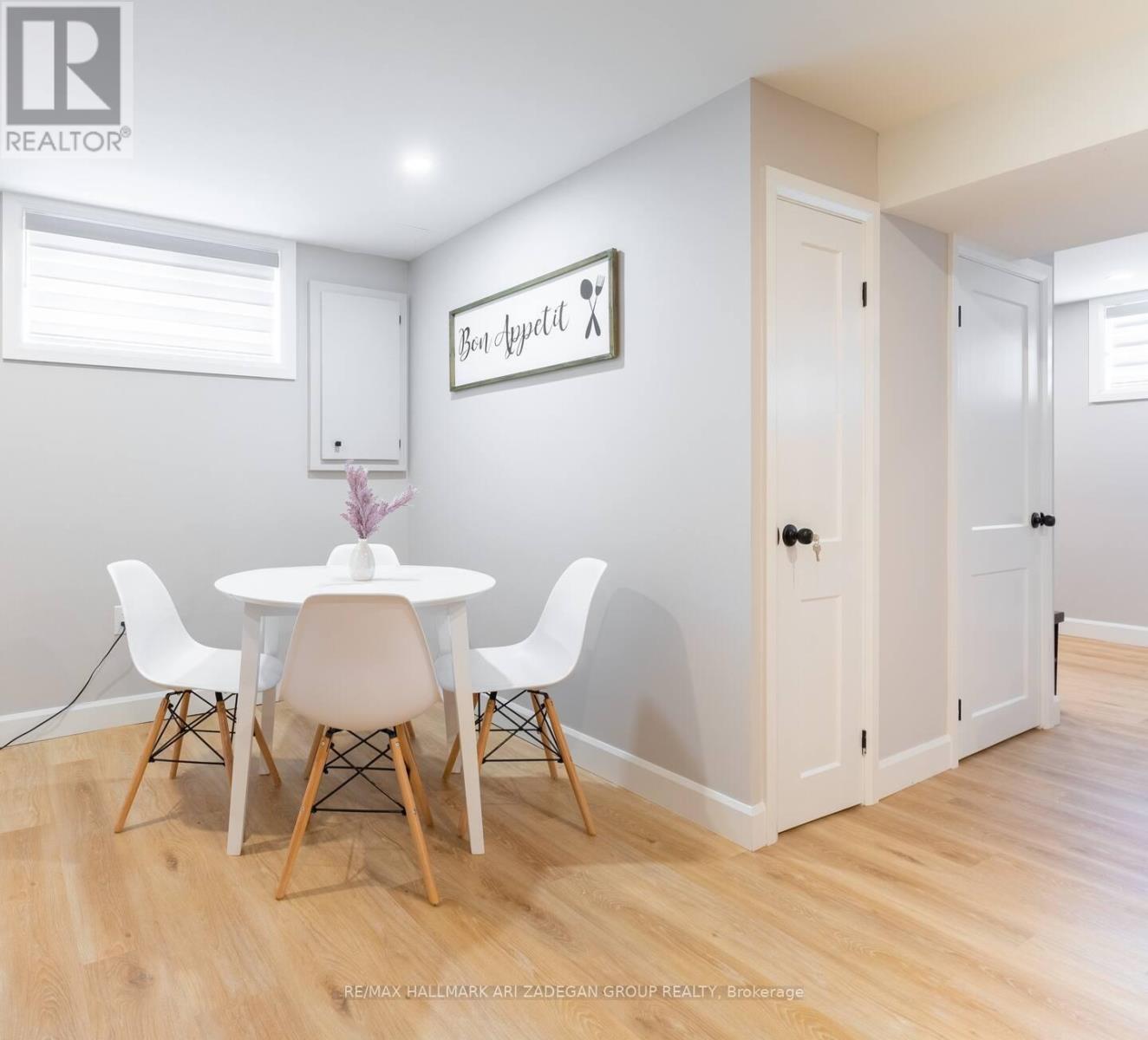 A dining room with a white table and chairs.