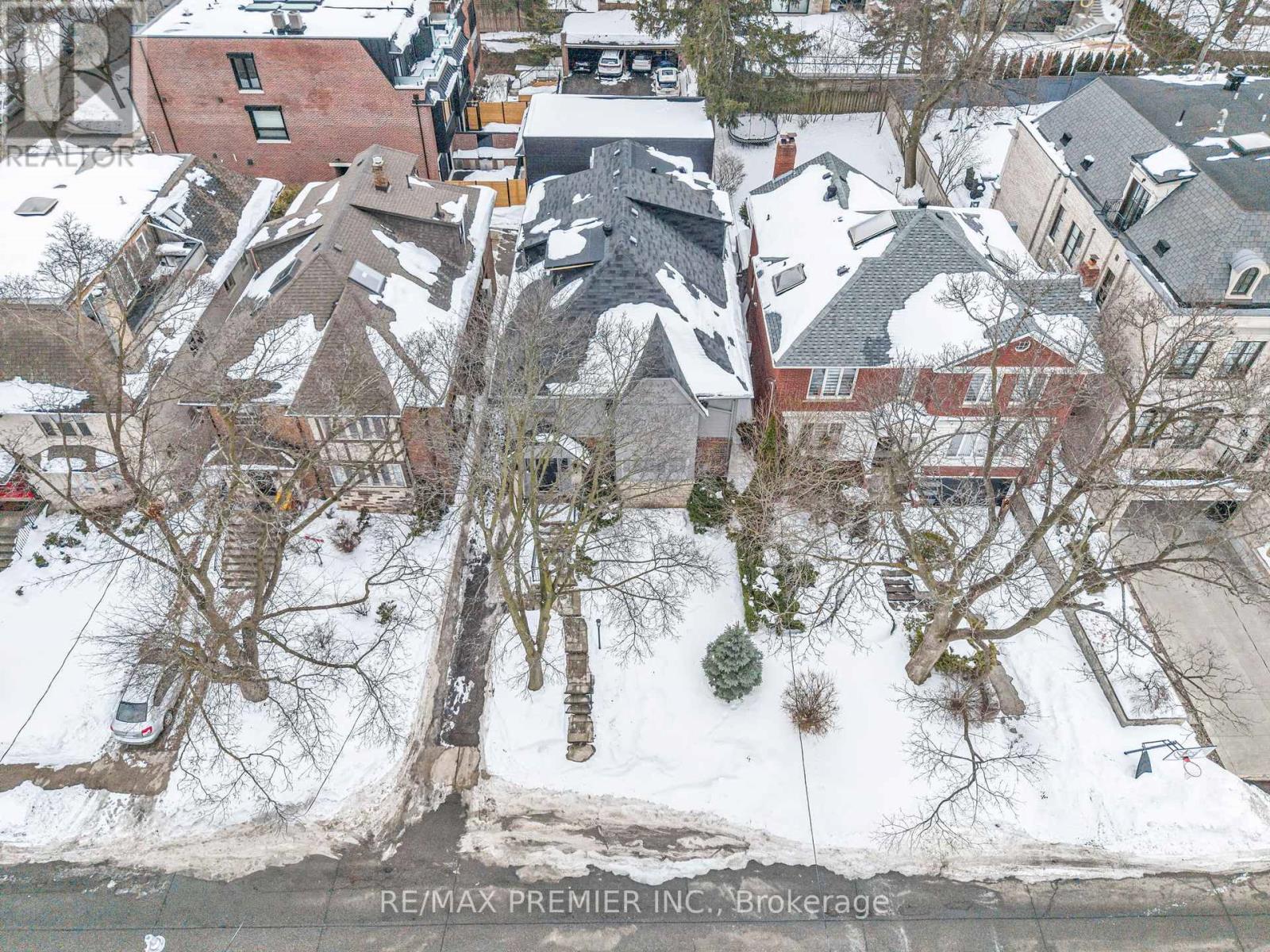 A bird's eye view of a snowy residential area with houses and trees.