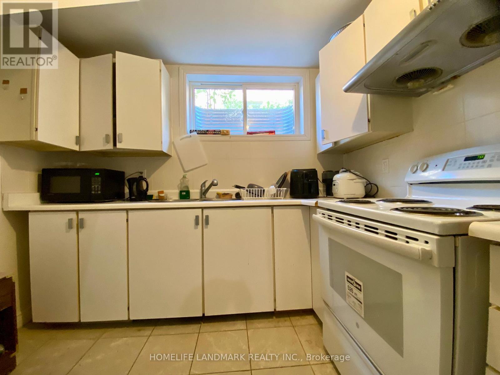 A kitchen with white cabinets and appliances.