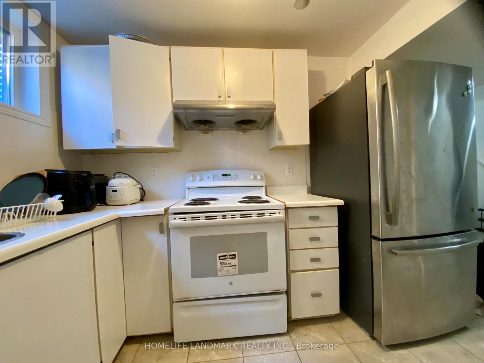 A kitchen with white cabinets and a stove top oven.