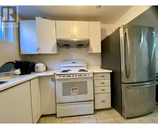 A kitchen with white cabinets and a stove top oven.
