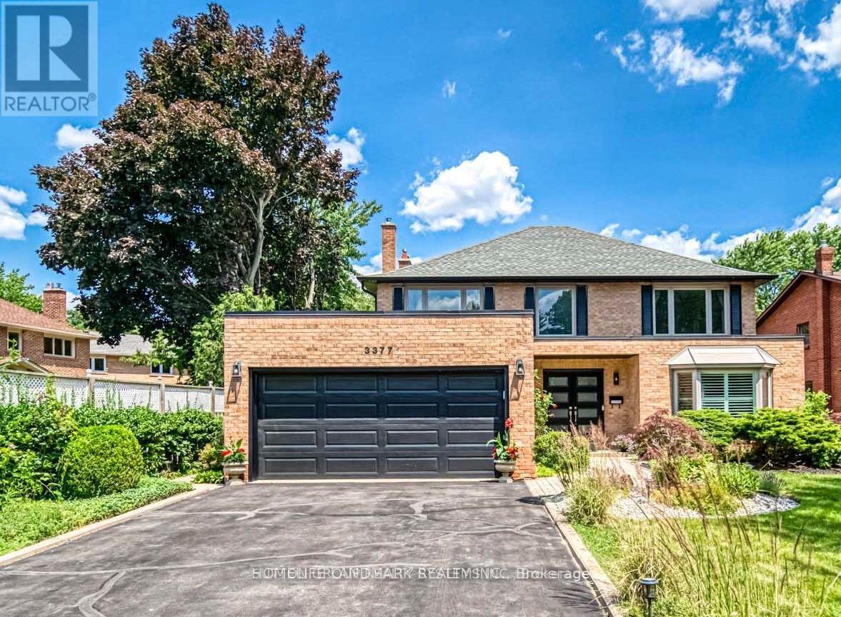 A house with a garage and a driveway in front of it.