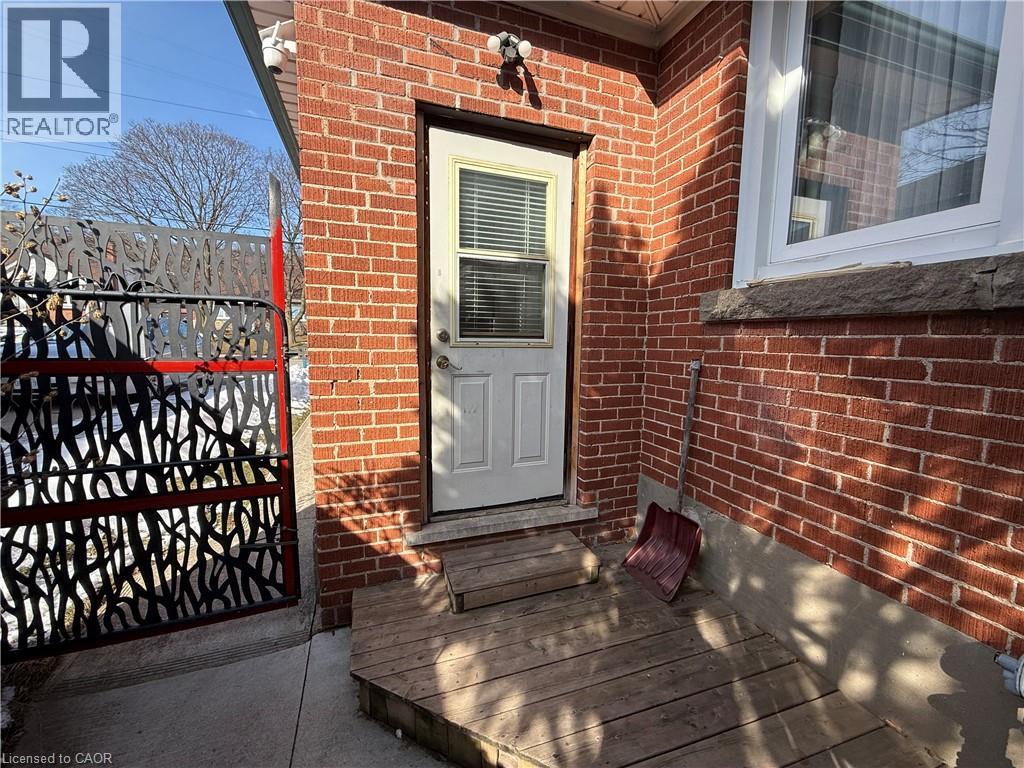 A red brick house with a white door and a black gate.