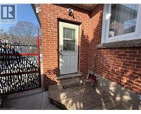 A red brick house with a white door and a black gate.