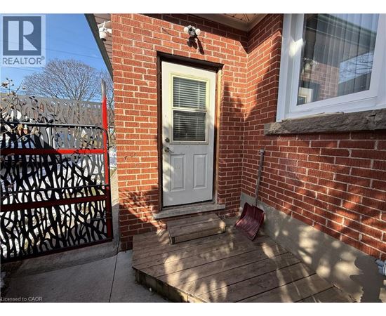 A red brick house with a white door and a black gate.