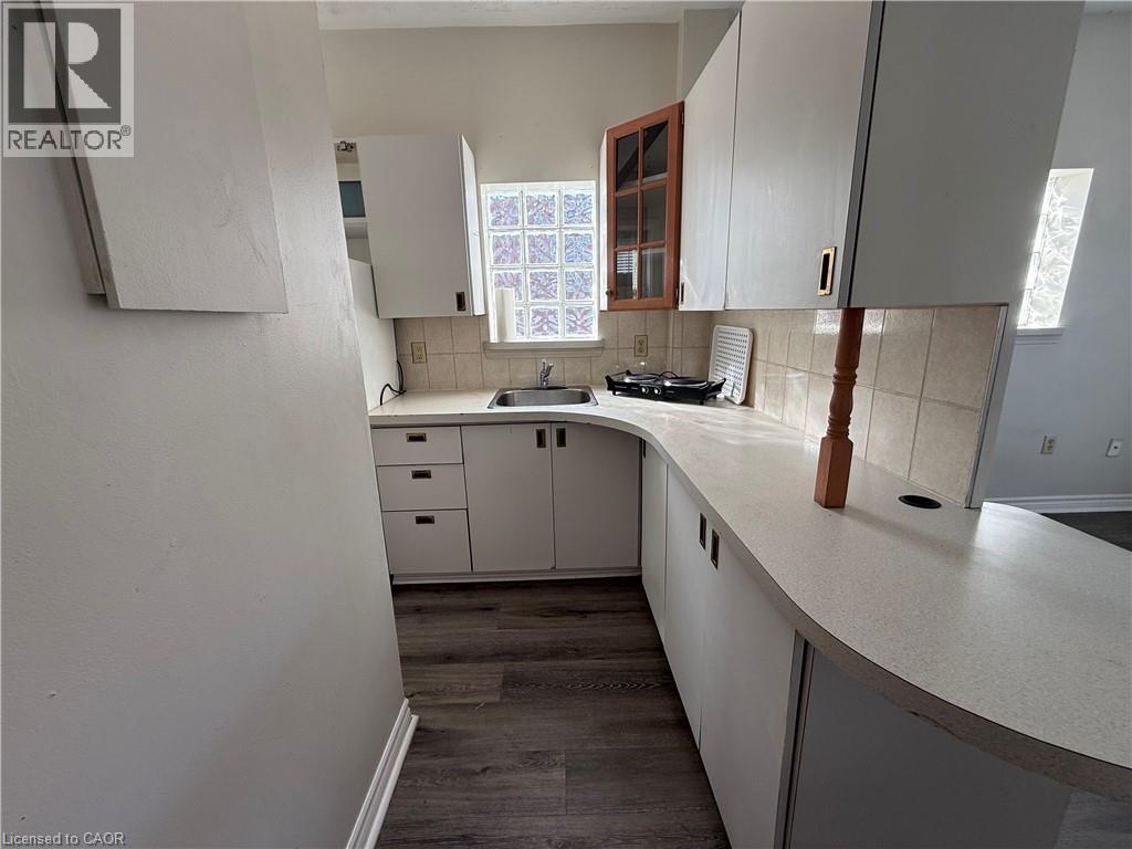 A kitchen with white cabinets and a wooden counter.