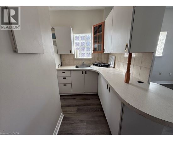 A kitchen with white cabinets and a wooden counter.