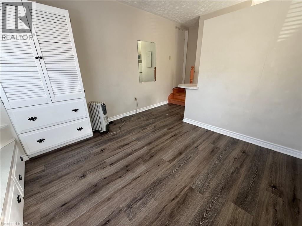 A bedroom with a wooden floor and white walls.