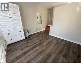 A bedroom with a wooden floor and white walls.