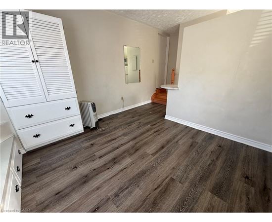 A bedroom with a wooden floor and white walls.