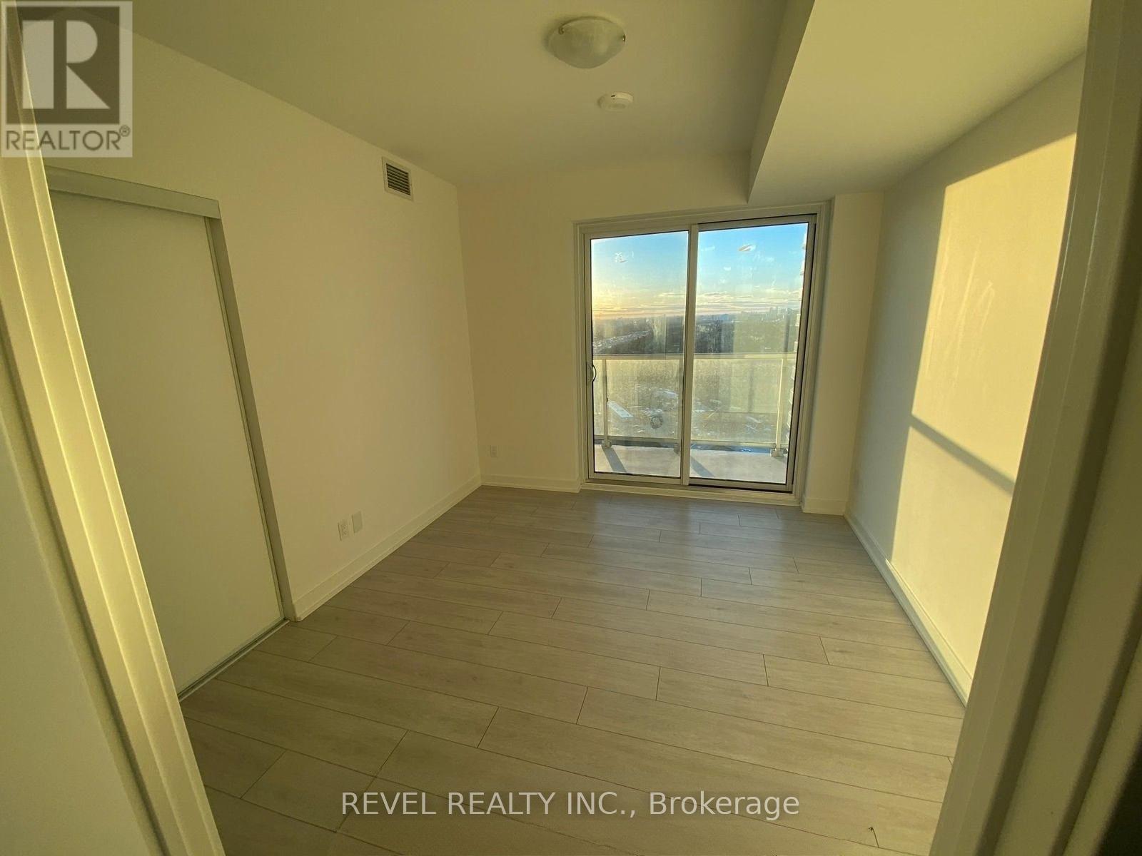 A room with a view of the city through a large window.