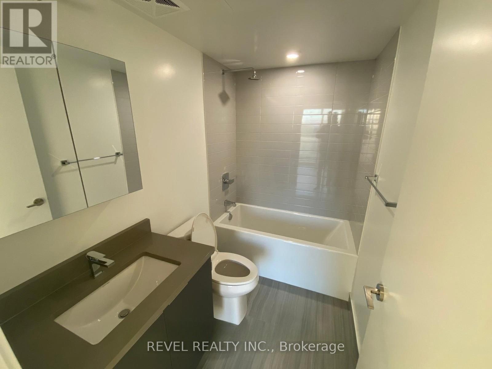 A bathroom with a toilet, sink, and bathtub.