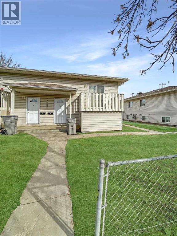 A house with a fence and a pathway leading to the front door.