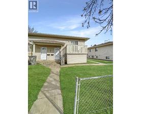 A house with a fence and a pathway leading to the front door.