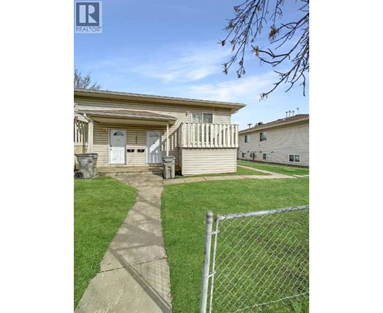A house with a fence and a pathway leading to the front door.