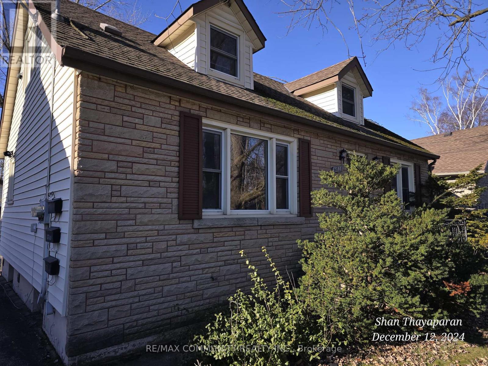 A house with a white siding and a brick chimney.