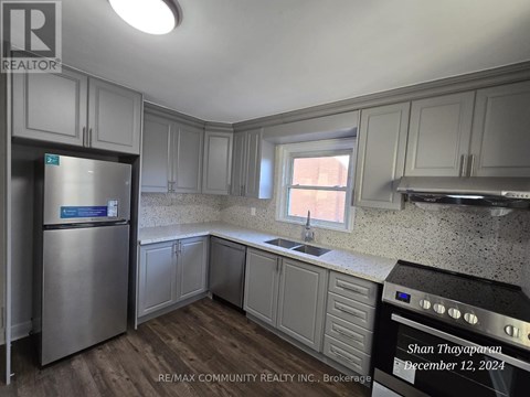 A kitchen with a stainless steel refrigerator and cabinets.