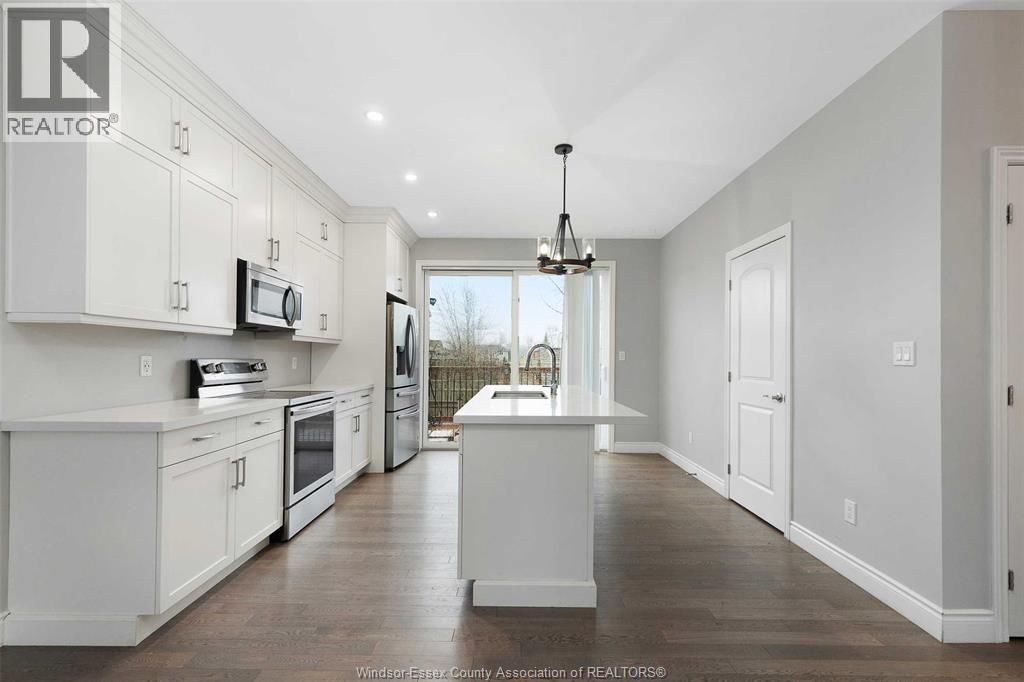 A well-lit kitchen with white cabinets and appliances.