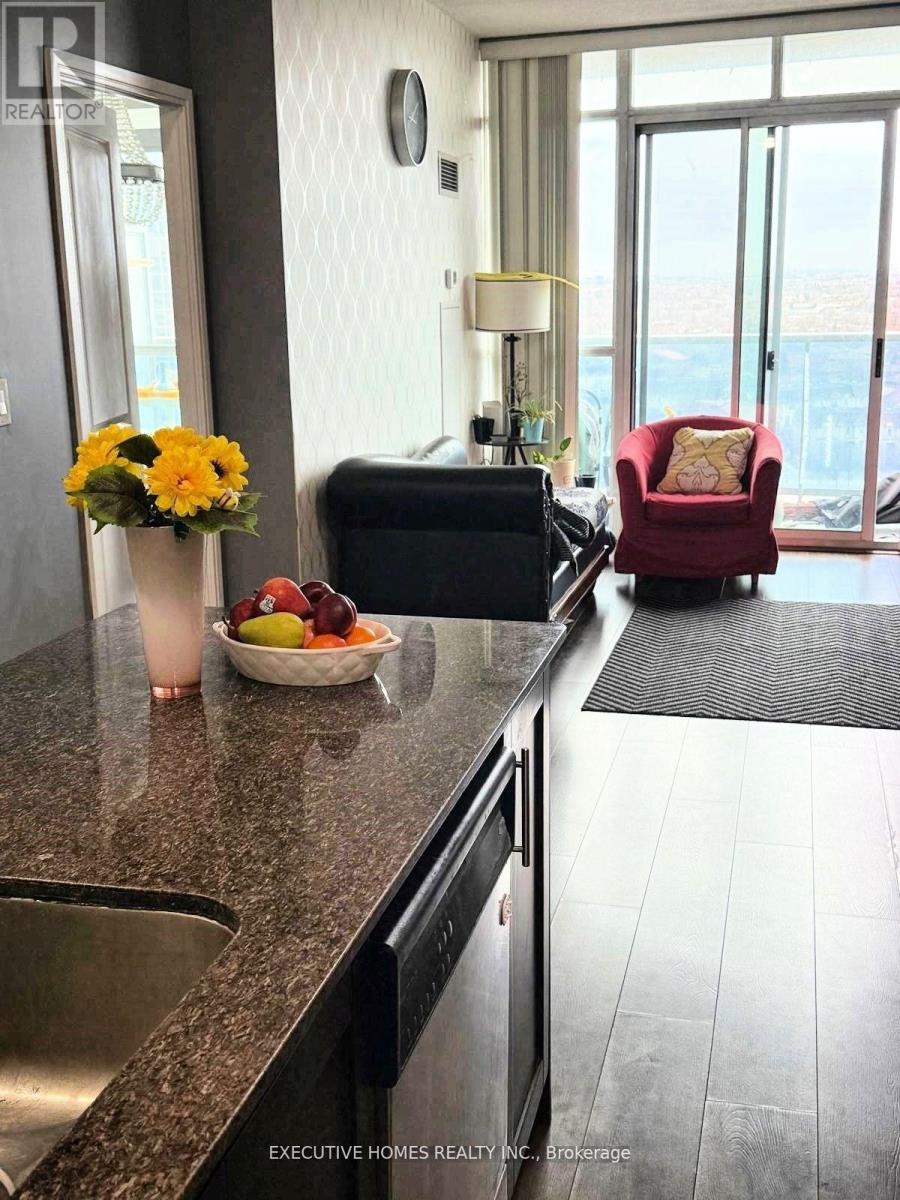 A kitchen with a red chair and a bowl of fruit on the counter.