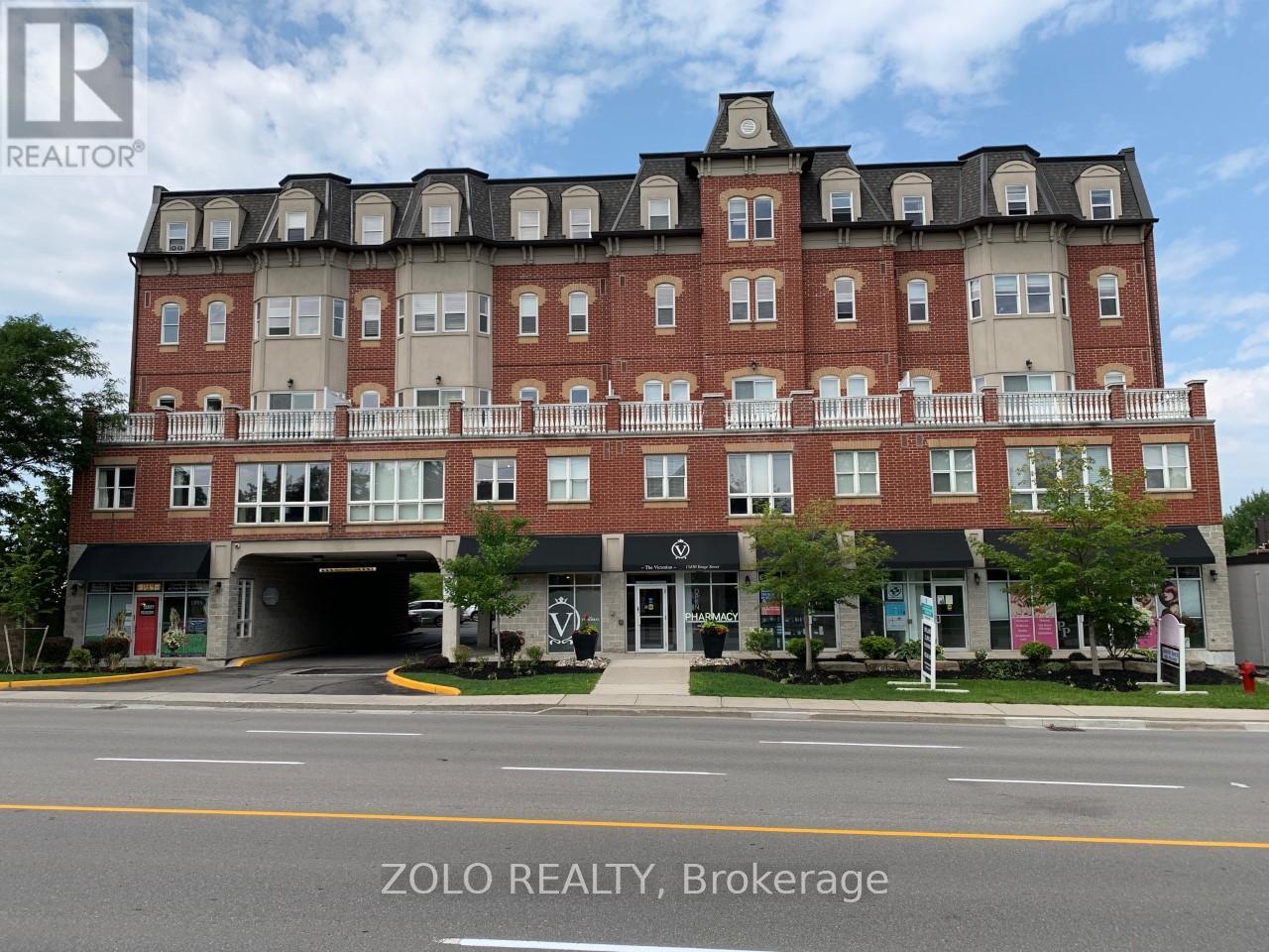 A large red brick building with a balcony on the top floor.