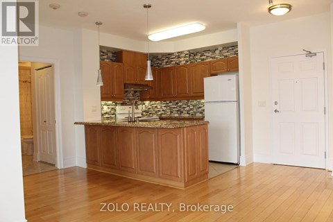 A kitchen with wooden cabinets and a marble backsplash.