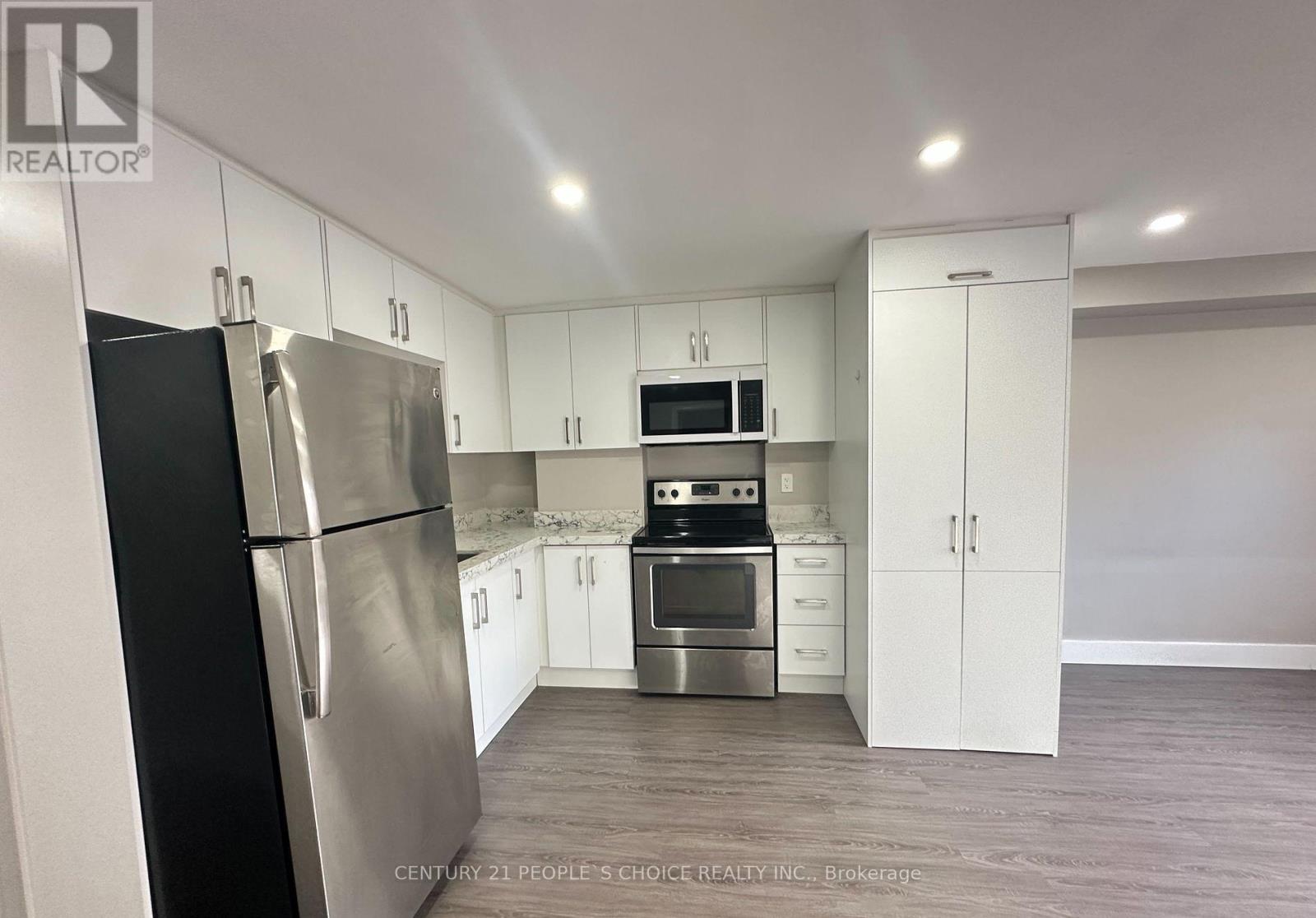 A kitchen with white cabinets and stainless steel appliances.