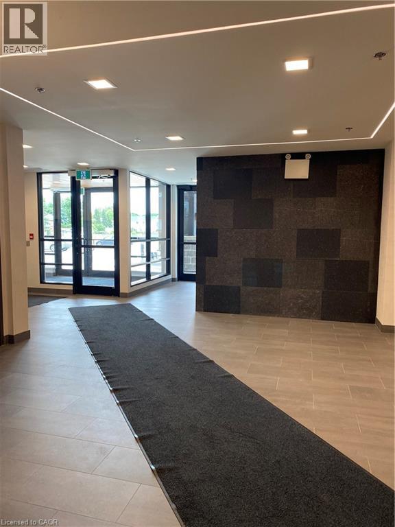 A hallway with a black carpet and a wall with a black and grey checkered pattern.