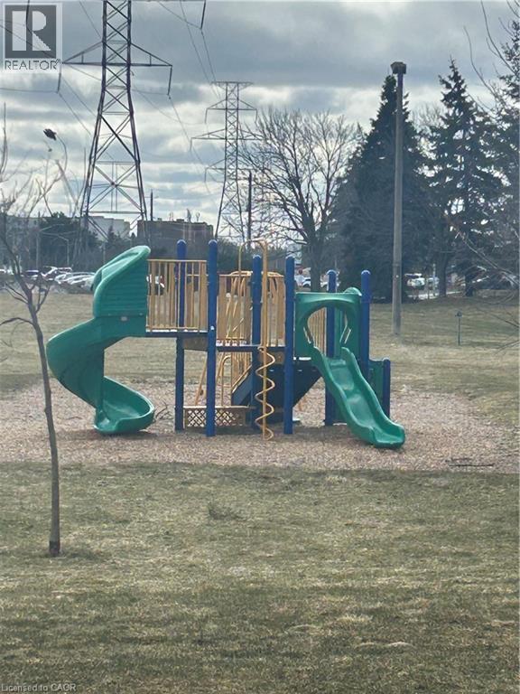 A playground with a green slide and a yellow and blue structure.