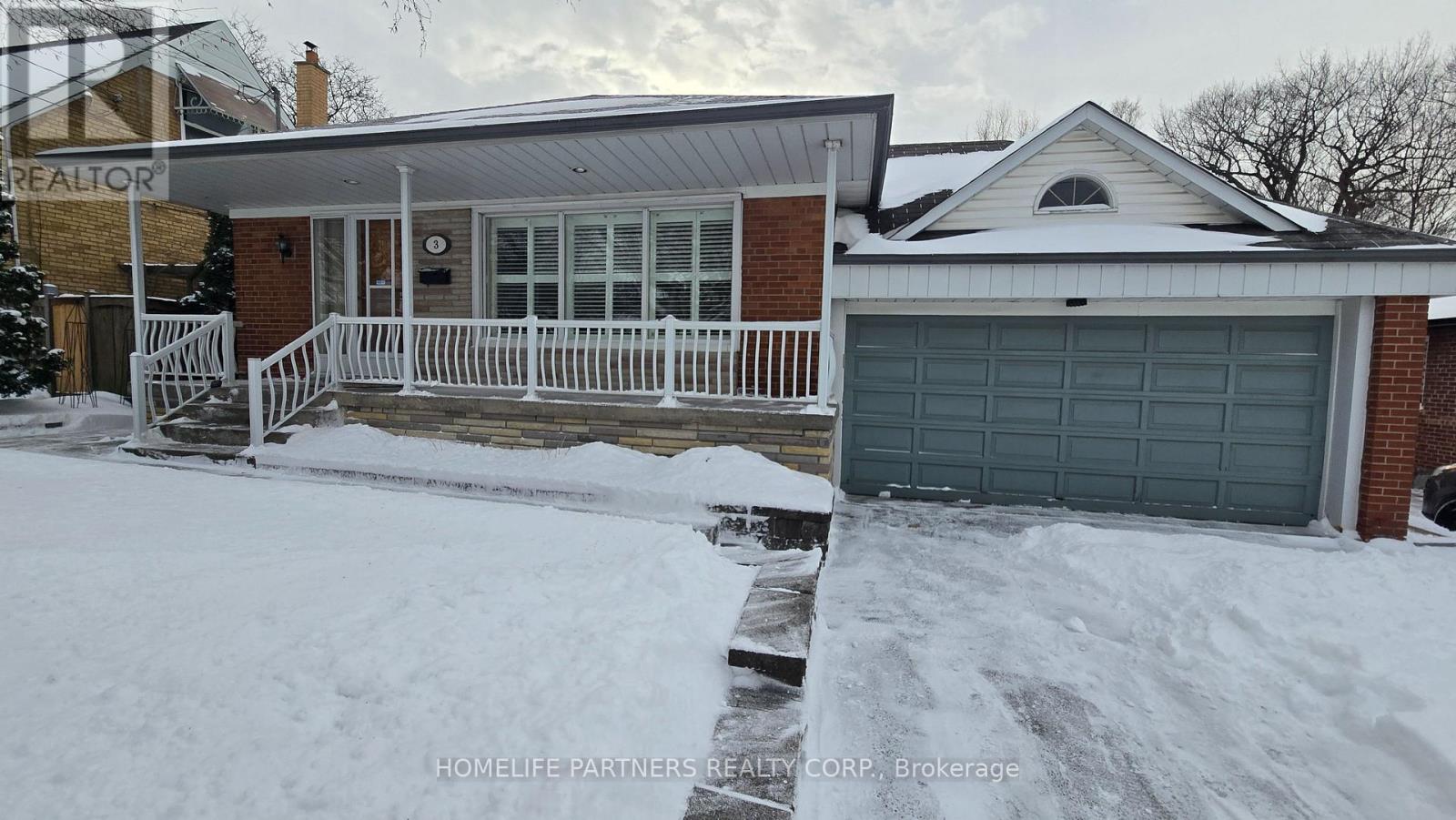 A house with a garage and a snow-covered front yard.